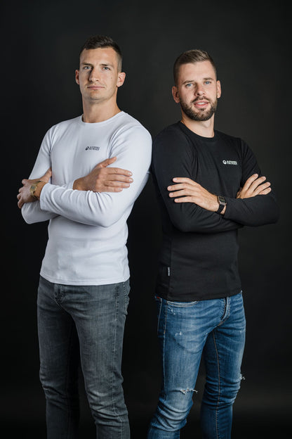 Dva moška nosita majici Tech Pro znamke Slovenski Patriot, eden v beli in drugi v črni 100% bombažni različici, narejeni v Sloveniji.