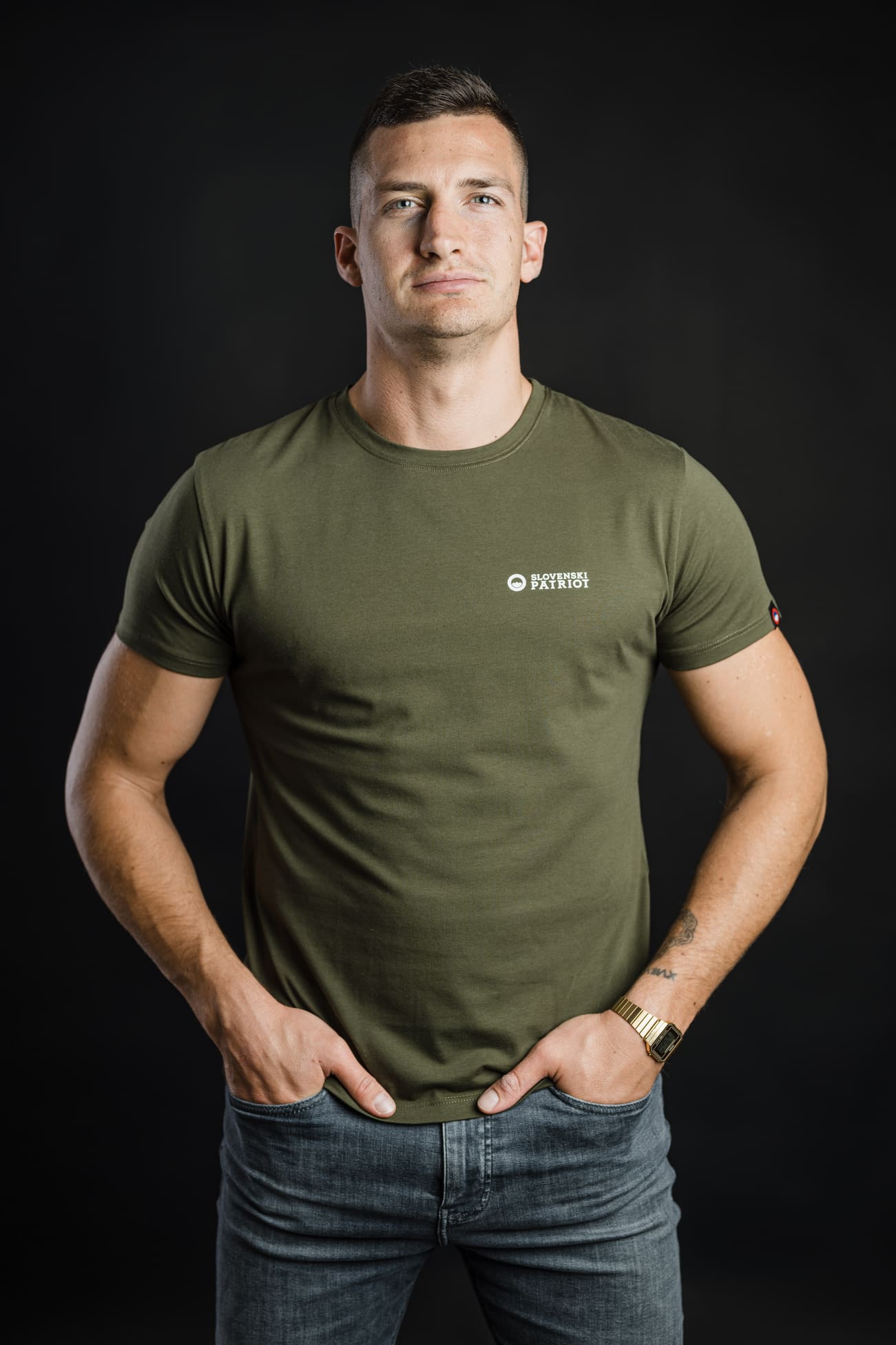 Moški v olivno zeleni majici FIT znamke Slovenski Patriot, narejeni v Sloveniji iz kakovostnega bombaža z belim logotipom na prsih.