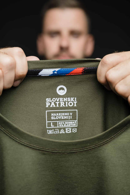 Detajl notranje etikete olivne majice FIT znamke Slovenski Patriot z napisom “Narejeno v Sloveniji”, oznako materialov in slovensko zastavo.